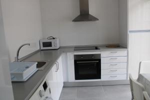 a white kitchen with a sink and a microwave at Casa chalet luxury emilia in Valencia