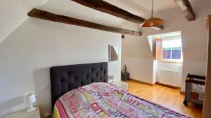 una camera da letto con letto con testiera nera e finestra di Maison de charme piscine couverte chauffée a Mayrinhac-Lentour Altre 24 foto
