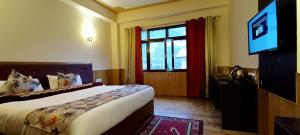 a hotel room with a bed and a television at Le Coxy Resort Lachung in Lachung