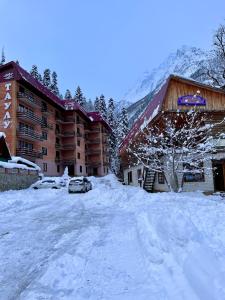 a snow covered parking lot in front of a lodge at Taulu in Dombay