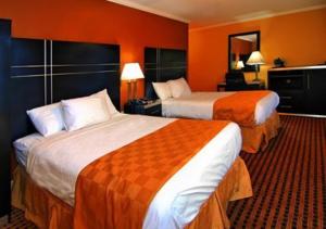 een hotelkamer met 2 bedden en oranje muren bij The Prince Hotel in Tunkhannock