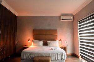 - une chambre avec un grand lit et une fenêtre dans l'établissement ANISA GUESTHOUSE, à Thohoyandou