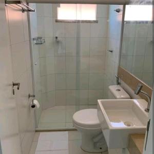 uma casa de banho com um WC, um chuveiro e um lavatório. em Apartamento na Praia do Saco - Condomínio Villa das Águas em Estância