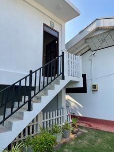 uma casa branca com escadas e plantas em Atrium Cottage em Seeduwa