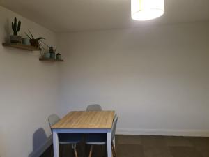 a table and chairs in a room with a white wall at Private room in a shared apartment II in Beauvais