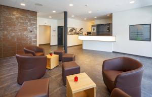 a waiting room with brown chairs and a counter at Villmergen Swiss Quality Hotel in Villmergen