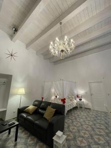 sala de estar con sofá negro y lámpara de araña en CasArcieri72, en Barletta
