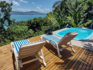 una terraza con 2 sillas y una piscina en Suite com piscina, en Florianópolis