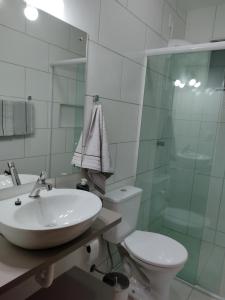 un bagno con lavandino, wc e doccia di Suite com piscina e jacuzzi a Florianópolis