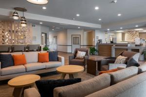 a lobby with couches and tables and a bar at Candlewood Suites Enterprise, an IHG Hotel in Enterprise