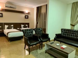 a hotel room with a bed and a couch and chairs at Ream Hotel Amman in Amman
