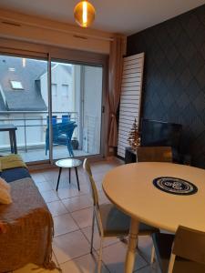 a living room with a table and a dining room at Superbe appartement in Saint-Quay-Portrieux