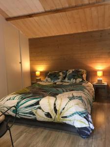 Bett in einem Zimmer mit Holzdecke in der Unterkunft Gîte «Les frênes » in Marigny