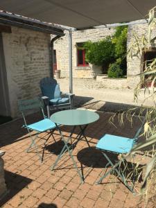 duas cadeiras e uma mesa e uma mesa e duas cadeiras em Gîte «Les frênes » em Marigny
