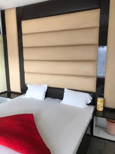 a bedroom with a white bed with a red blanket at Hotel Abhishek in Jhānsi