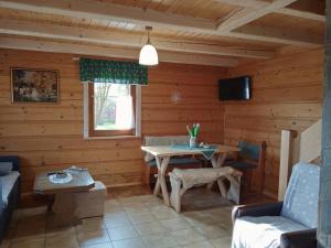 una sala de estar con una mesa en una cabaña de madera en Domek Na kympkach en Istebna