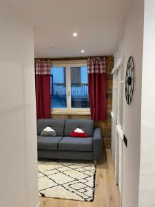 a living room with a couch and a window at Charmant 2 pièces cosy au cœur de Saint-Gervais in Saint-Gervais-les-Bains