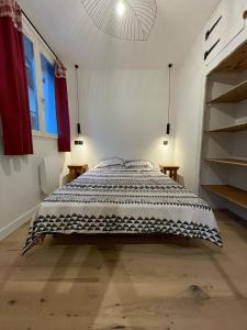 um quarto com uma cama com um cobertor preto e branco em Charmant 2 pièces cosy au cœur de Saint-Gervais em Saint-Gervais-les-Bains
