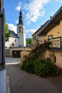 un edificio con una torre dell'orologio e un cartello con dei fiori di Charmant 2 pièces cosy au cœur de Saint-Gervais a Saint-Gervais-les-Bains