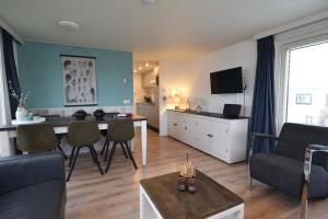 a living room with a couch and a dining room at Chalet Duinzicht G68 Ameland in Buren