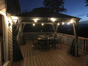 a deck with a table and chairs and lights at Spectacular Valley View in Wine Country in Newberg