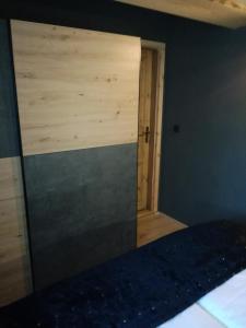 1 dormitorio con pared de madera y espejo en LES CHALET Kranjska Gora I, en Kranjska Gora