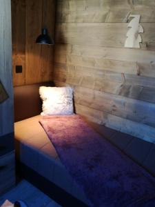 Bett in einem Zimmer mit einer Holzwand in der Unterkunft LES CHALET Kranjska Gora I in Kranjska Gora