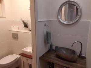 La salle de bains est pourvue d'un lavabo et d'un miroir mural. dans l'établissement Ady Apartman, à Tata