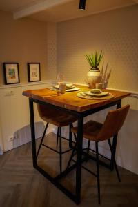 drewniany stół z dwoma krzesłami i rośliną na nim w obiekcie B&B Mañana w mieście Cuijk