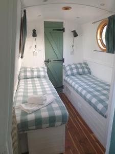 a small room with two beds and a green door at Cambridge Boat Hire in Chesterton +6 photos