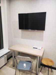 a table with two chairs and a television on a wall at NEW STUDIO in ARCADIA in Odesa