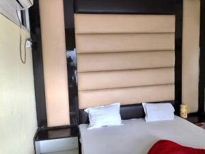 Una cama con dos almohadas blancas encima. en Hotel Abhishek en Jhānsi