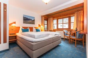 a bedroom with a bed and a desk and a chair at Landgasthof Neuwirt in Lofer