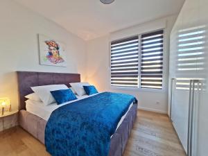a bedroom with a large bed with blue sheets at Apartment StellaMare in Split