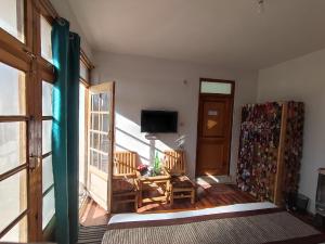 sala de estar con mesa, sillas y TV en Snow Lion Ladakh en Leh