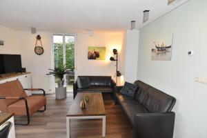sala de estar con sofá y mesa de centro en Vakantiehuis Tjeukemeer, de Friese Meren, en Rohel