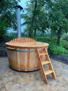 bañera de hidromasaje de madera con escalera en un parque en Wildwestruurlo, en Ruurlo