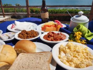 uma mesa com pratos de comida para o pequeno almoço em HOTEL DAS FALESIAS em Beberibe