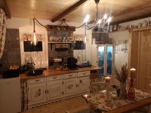a kitchen with white cabinets and a table in a room at The Little Blue House in Reşiţa