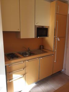 a small kitchen with a sink and a refrigerator at Ale's residence in Casal Palocco