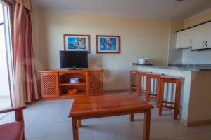 a kitchen with a wooden table and some bar stools at WiFi Costa Adeje in Adeje