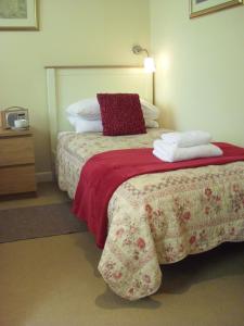 a bedroom with a bed with a red blanket and pillows at The Engine Shed in Weston-super-Mare