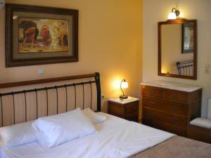 a bedroom with a bed and a dresser and a mirror at GARDEN VILLAS in Ayia Evfimia