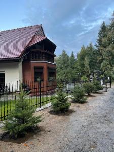 a house with christmas trees in front of a fence at Willa Górska in Karpacz