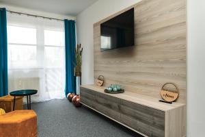 a living room with a flat screen tv on a wall at Apartman Artemis in Bešeňová