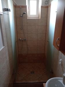 La salle de bains est pourvue d'une douche et d'un lavabo. dans l'établissement Joe Beach Apartman, à Keszthely