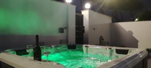 bagno con vasca verde e bicchieri di vino di Villa Kinga ad Anzio