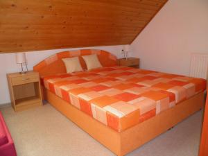 1 dormitorio con 1 cama grande de color naranja y 2 mesitas de noche en Privat Kovacova, en Žiar