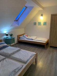 sypialnia z 2 łóżkami i niebieskim dachem w obiekcie Pokoje ArkaSasino z sauną ogrodową w Sasinie