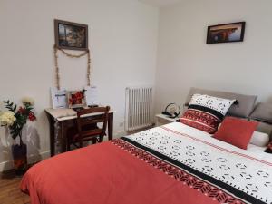 sypialnia z łóżkiem i biurkiem z krzesłem w obiekcie LES PINGOUINS DE LA MARNE w mieście Le Perreux-Sur-Marne